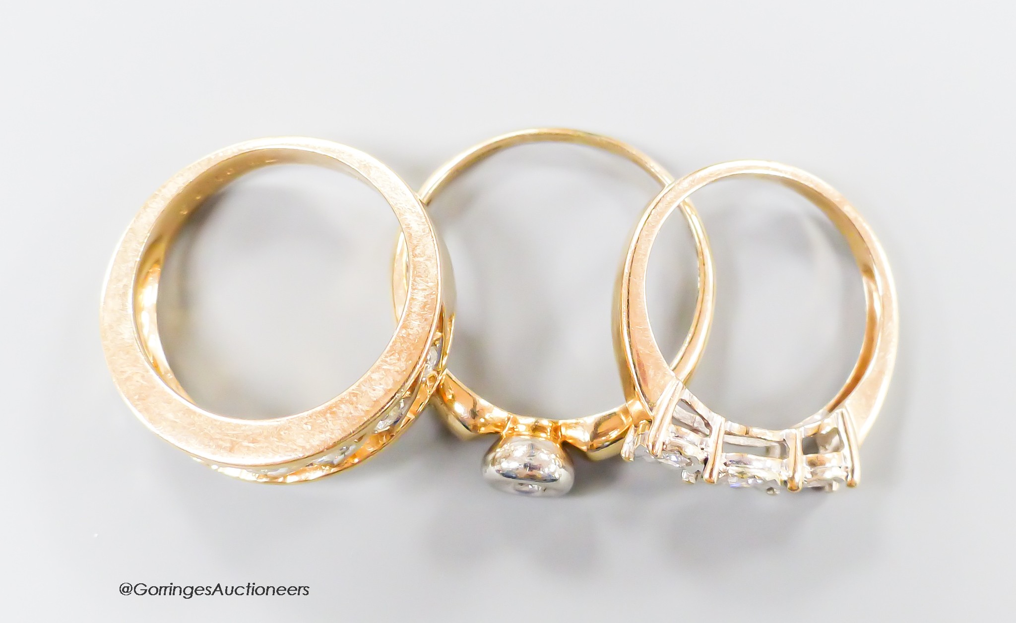 Three assorted modern 9ct gold and diamond set dress rings, including illusion set three stone and solitaire, gross weight 9.5 grams.